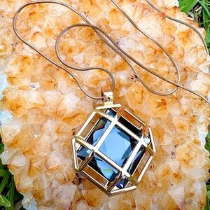 Gold Cage Pendant Necklace with Deep Blue Faceted Stone